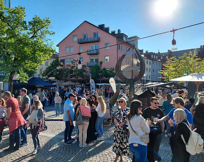 Menschen tanzen und lachen auf dem Adenauerplatz