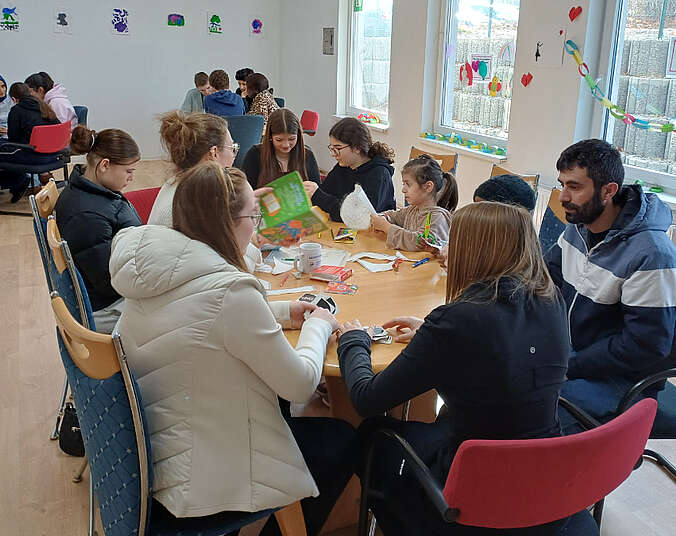 Die Jugendlichen mit den Bewohnern und Bewohnerinnen beim Basteln im Aufenthaltsraum.