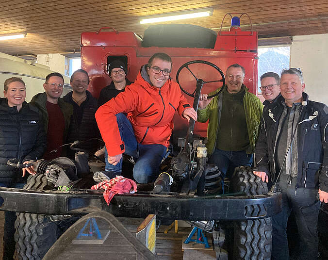 Mehrere Männer vor ihrem Unimog.