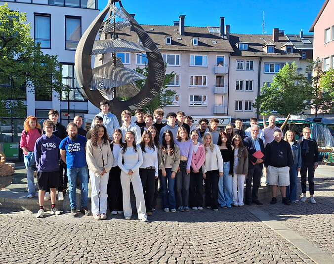 Gruppe Schülerinnen und Schüler vor dem Brunnen auf dem Adenauerplatz