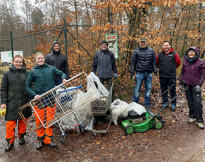 Männer und Frauen mit einem Berg an Müll
